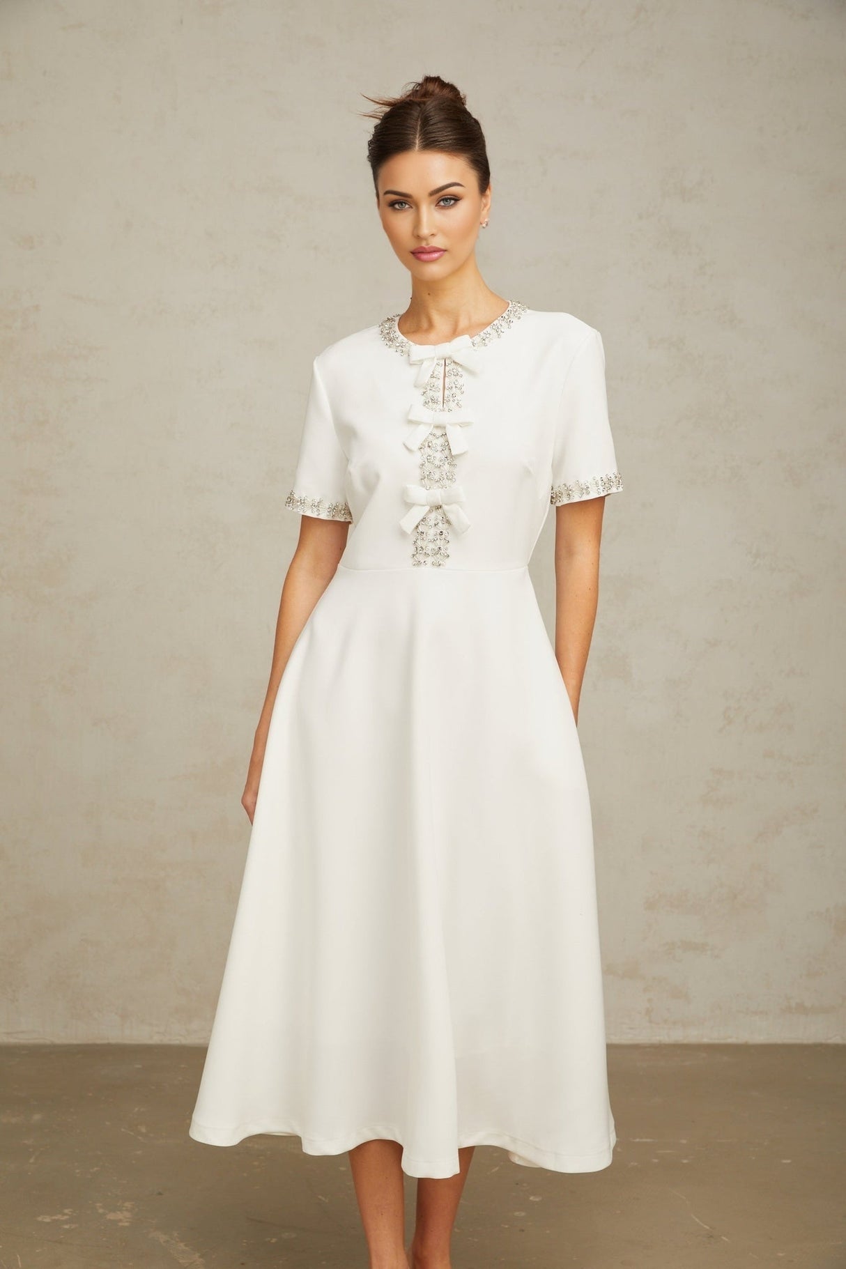 White midi dress with crystal accents and bow detail named Cassiopeia