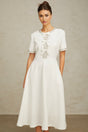 White midi dress with crystal accents and bow detail named Cassiopeia