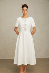 White midi dress with crystalaccented bow and Cassiopeia inspired design
