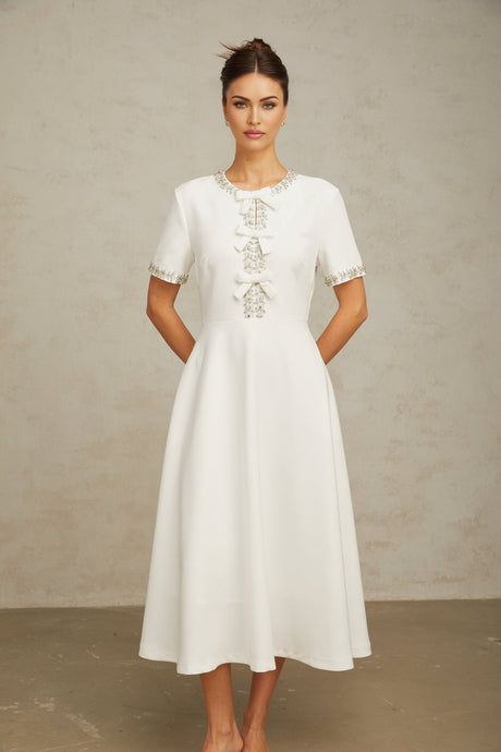 White midi dress with crystalaccented bow and Cassiopeia inspired design