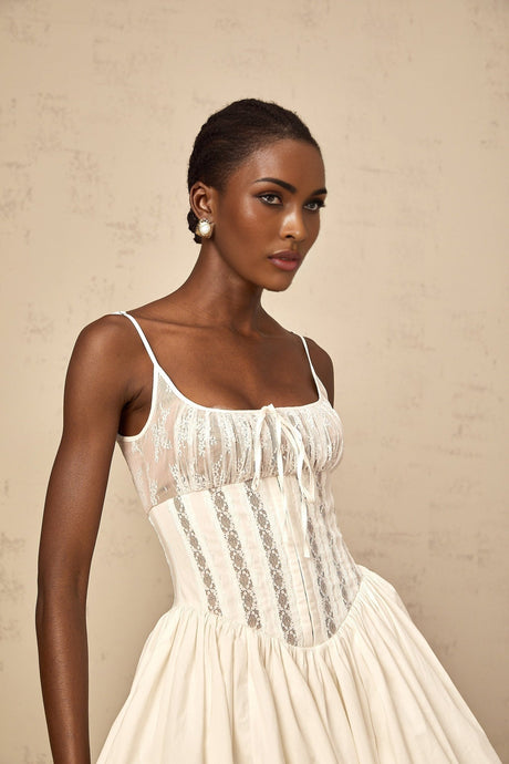White mini dress with lace details and corset style bodice featuring floral design elements