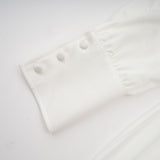 White mini dress with ruched detailing and faux flower embellishments called Maeva