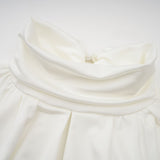 White mini dress with ruched detailing and faux flower embellishments called Maeva