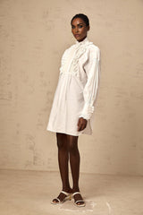 White mini shirt dress with lace trim and ruffles featuring a Melina design