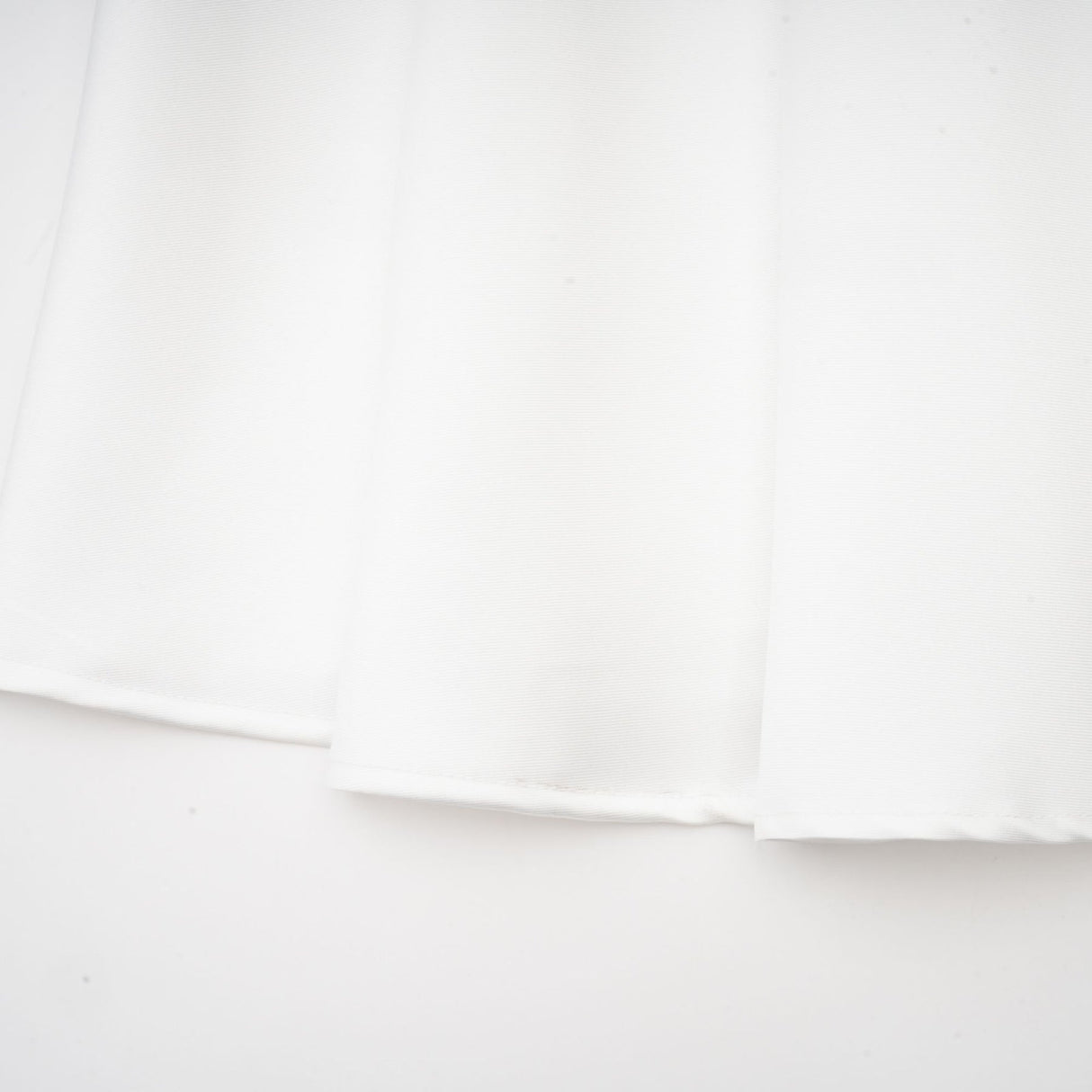White offshoulder maxi dress with panelling worn by model standing against plain background