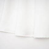 White offshoulder maxi dress with panelling worn by model standing against plain background