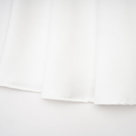 White offshoulder maxi dress with panelling worn by model standing against plain background