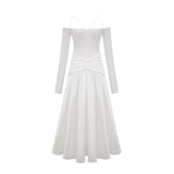 White offshoulder maxi dress with panels worn by model standing against plain background