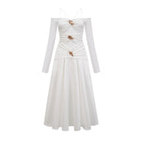 White offshoulder maxi dress with panels worn by model standing in relaxed pose