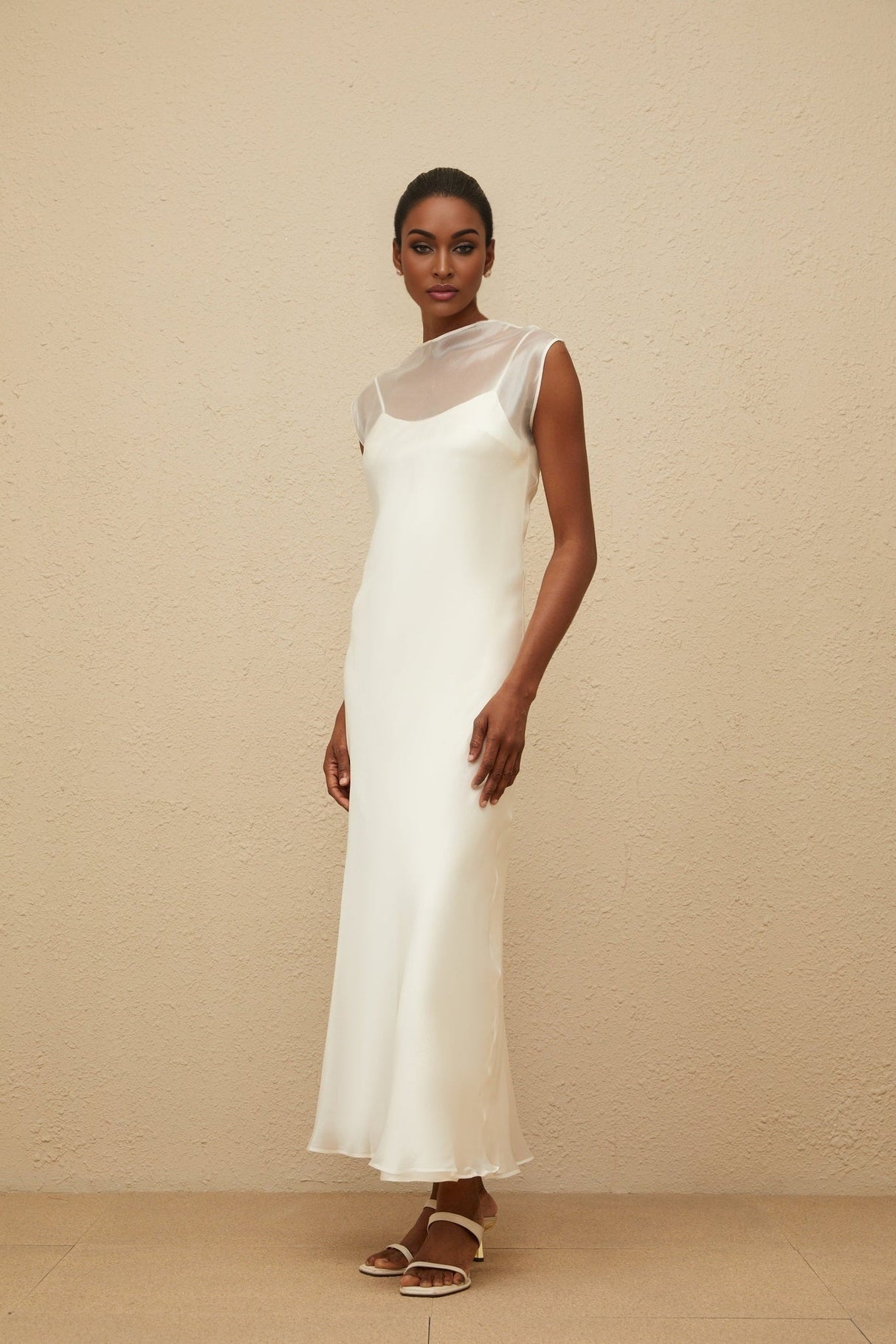 White sleeveless tulle maxi dress with flared hem and round neck