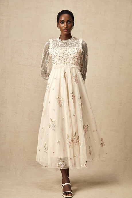 White tulle midi dress with colorful floral embroidery by Celine featuring sheer sleeves and delicate floral patterns throughout the bodice and skirt
