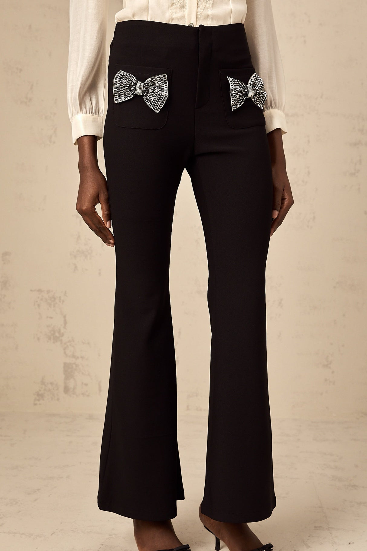 White wide leg trousers with decorative bow detail at waist