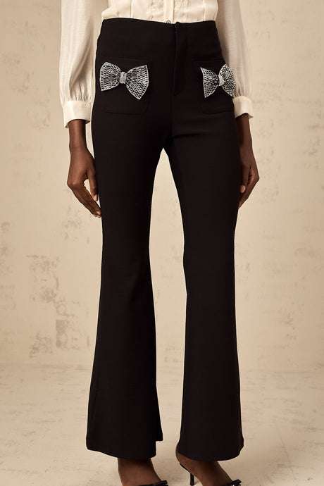 White wide leg trousers with decorative bow detail at waist