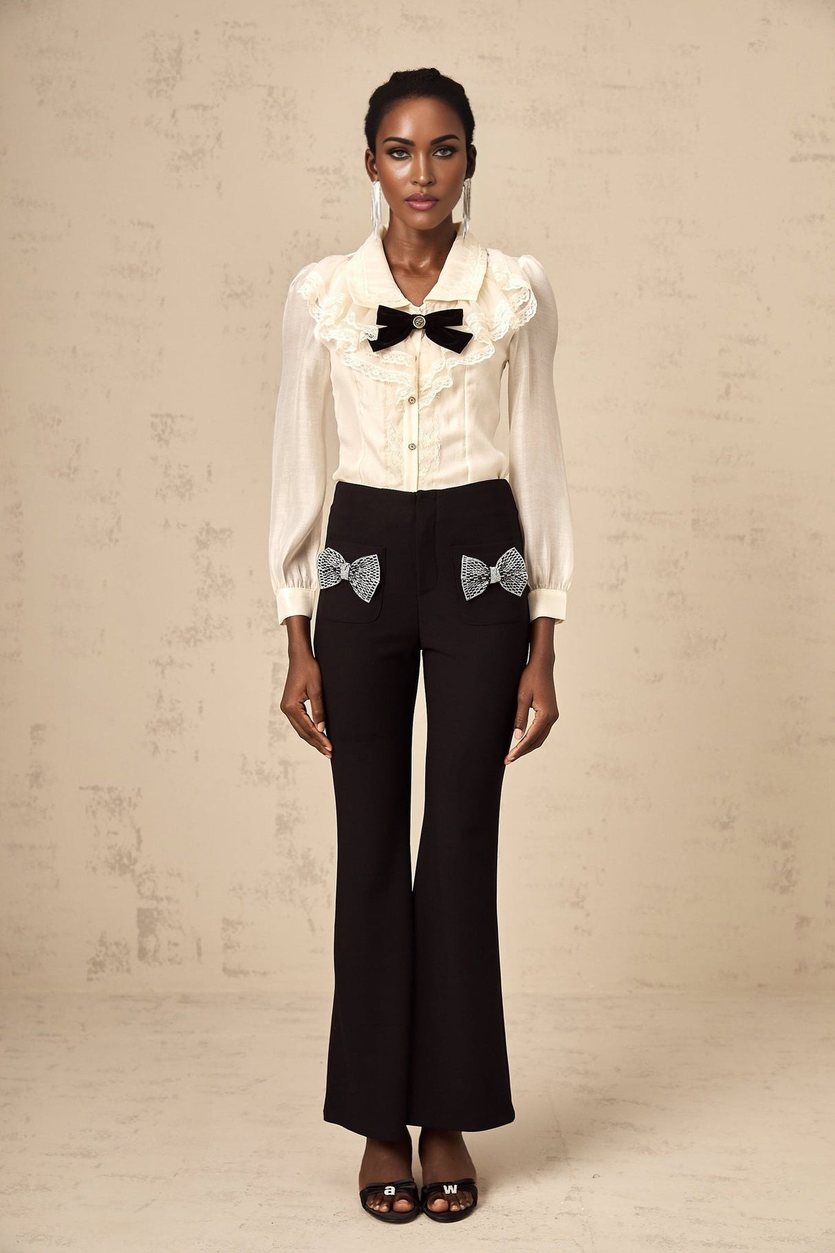 Wideleg trousers with decorative bow detail at waist in a flared silhouette