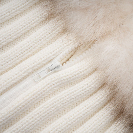 Woman wearing a beige faux fur jacket with ribbed knit texture and cozy collar
