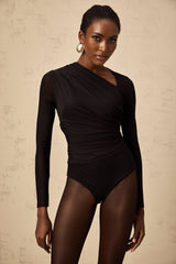 Woman wearing a black bodysuit with asymmetric design and split detailing