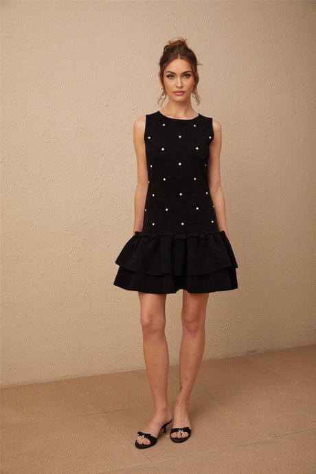 Woman wearing a black knitted mini dress with bead embellishments