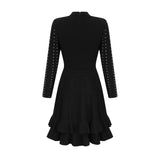 Woman wearing a black knitted mini dress with embellishments and ruffles