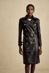 Woman wearing a black leather coat with double breasted front and belt cinched at waist