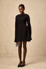 Woman wearing a black longsleeve mini dress with a flared skirt