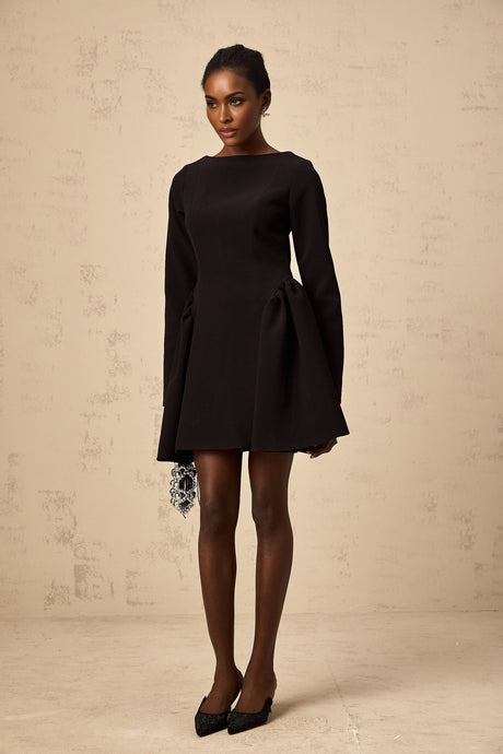 Woman wearing a black longsleeve mini dress with a flared skirt