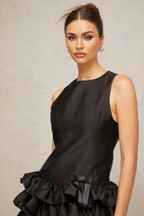 Woman wearing a black mini dress with tiered ruffles and short sleeves
