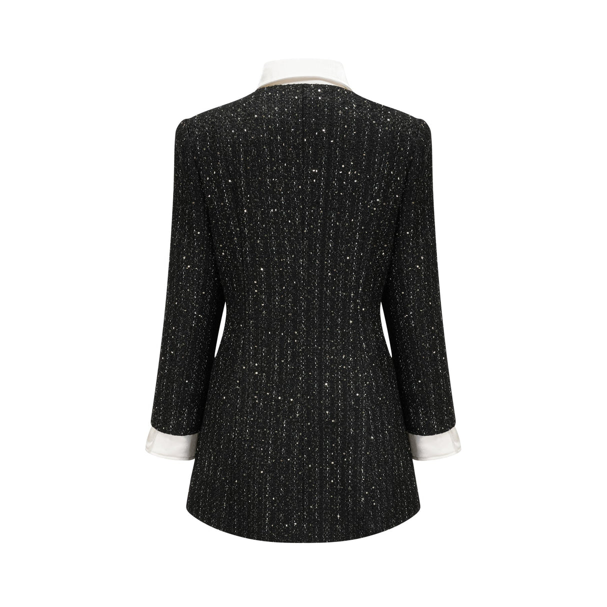 Woman wearing a black mini dress with tweed fabric and sequin panels Audrey style dress with short length and mixed textures