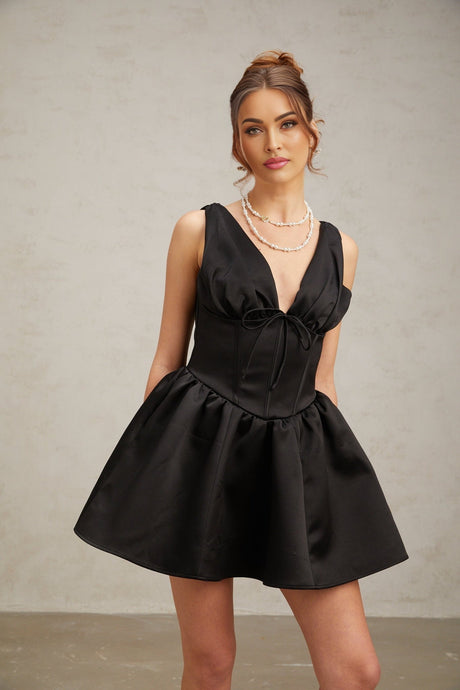 Woman wearing a black mini dress with Vneck and flared skirt