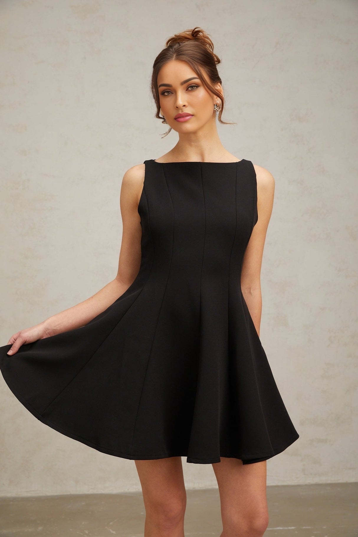 Woman wearing a black sleeveless mini dress with a flared skirt