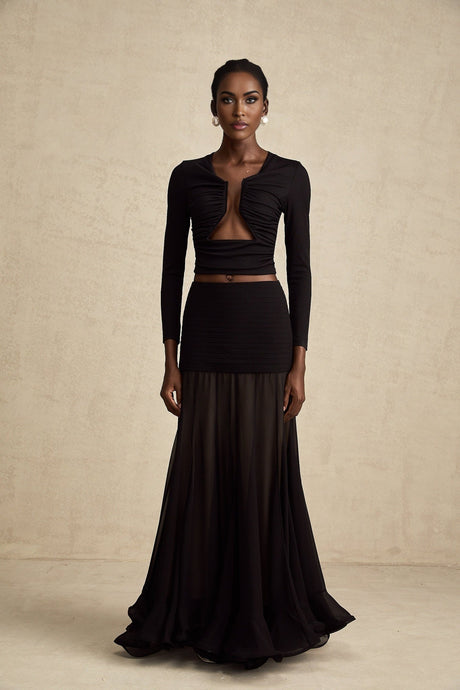 Woman wearing a black sleeveless top with open front and gathered details