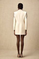 Woman wearing a blazer dress covered in sequins with embellishments