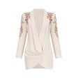 Woman wearing a blazer dress covered in shimmering sequins with embellished details