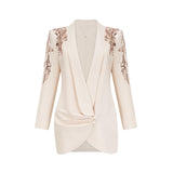 Woman wearing a blazer dress covered in shimmering sequins with embellished details