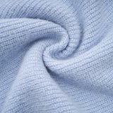 Woman wearing a blue knit blouse and matching skirt set called Chantal The outfit features a coordinated top and bottom in a soft knitted fabric with a blue color