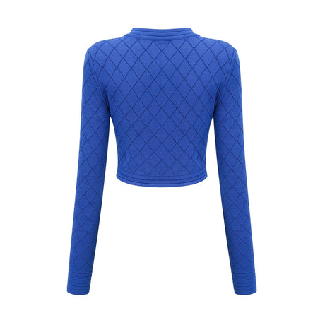 Woman wearing a blue knitted matching set consisting of a top with button details and a skirt