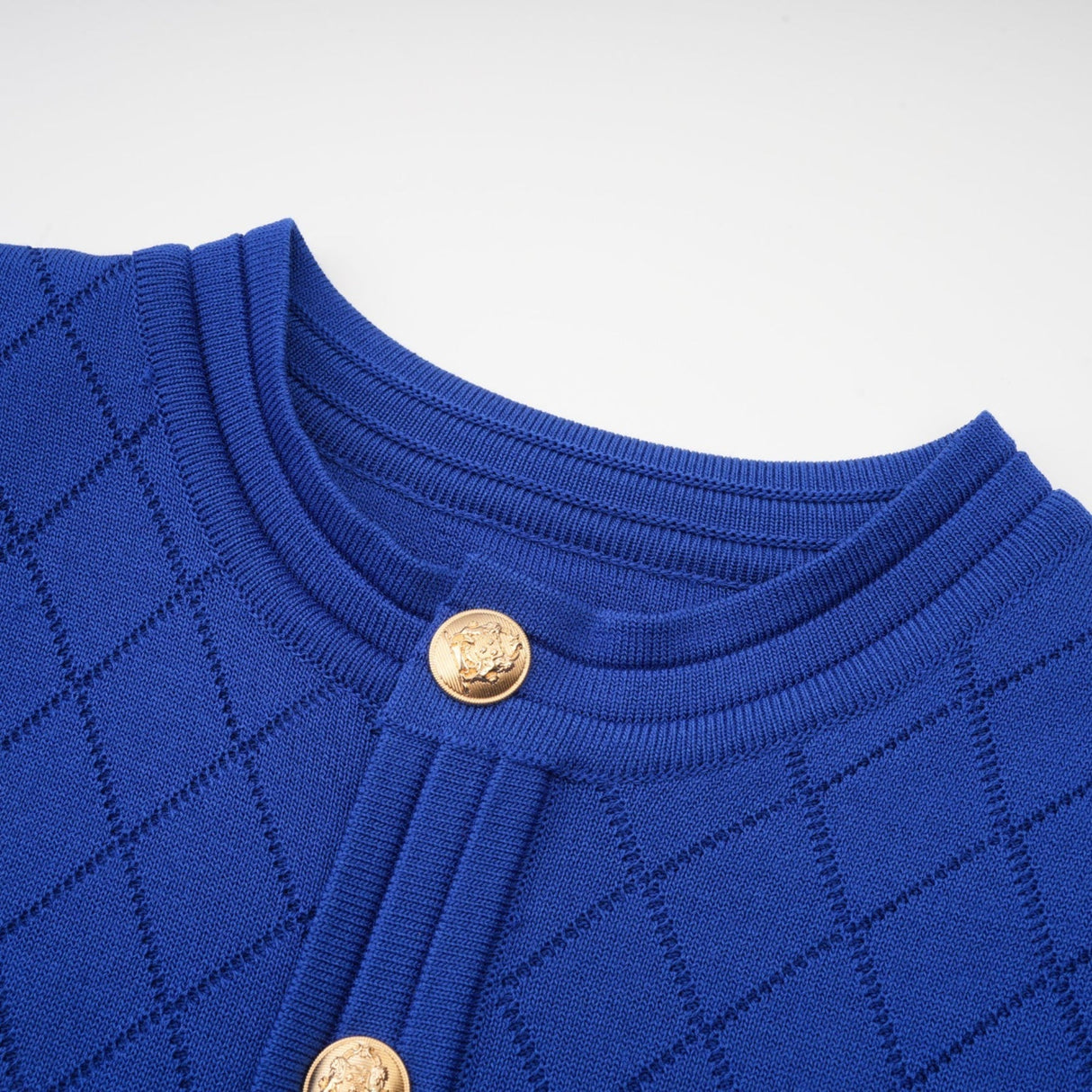 Woman wearing a blue knitted two piece outfit consisting of a top with button details and a matching skirt