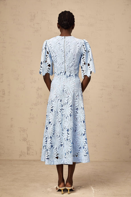 Woman wearing a blue lace top and matching skirt set in Audrey style with guipure lace detailing