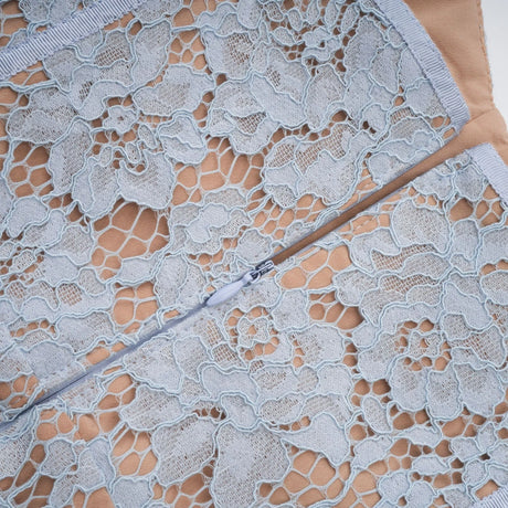 Woman wearing a blue midi dress with floral lace pattern and boned bodice