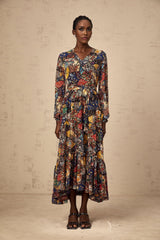 Woman wearing a brown bohemian style midi dress with shirring detail and flowing skirt