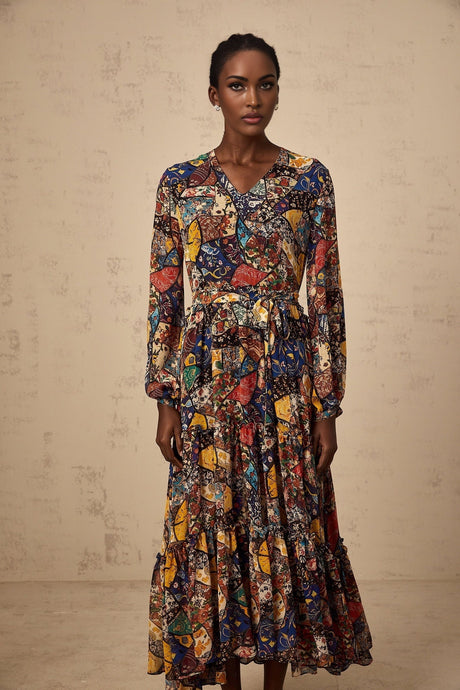 Woman wearing a brown bohemian style midi dress with shirring details and flowy sleeves in outdoor setting