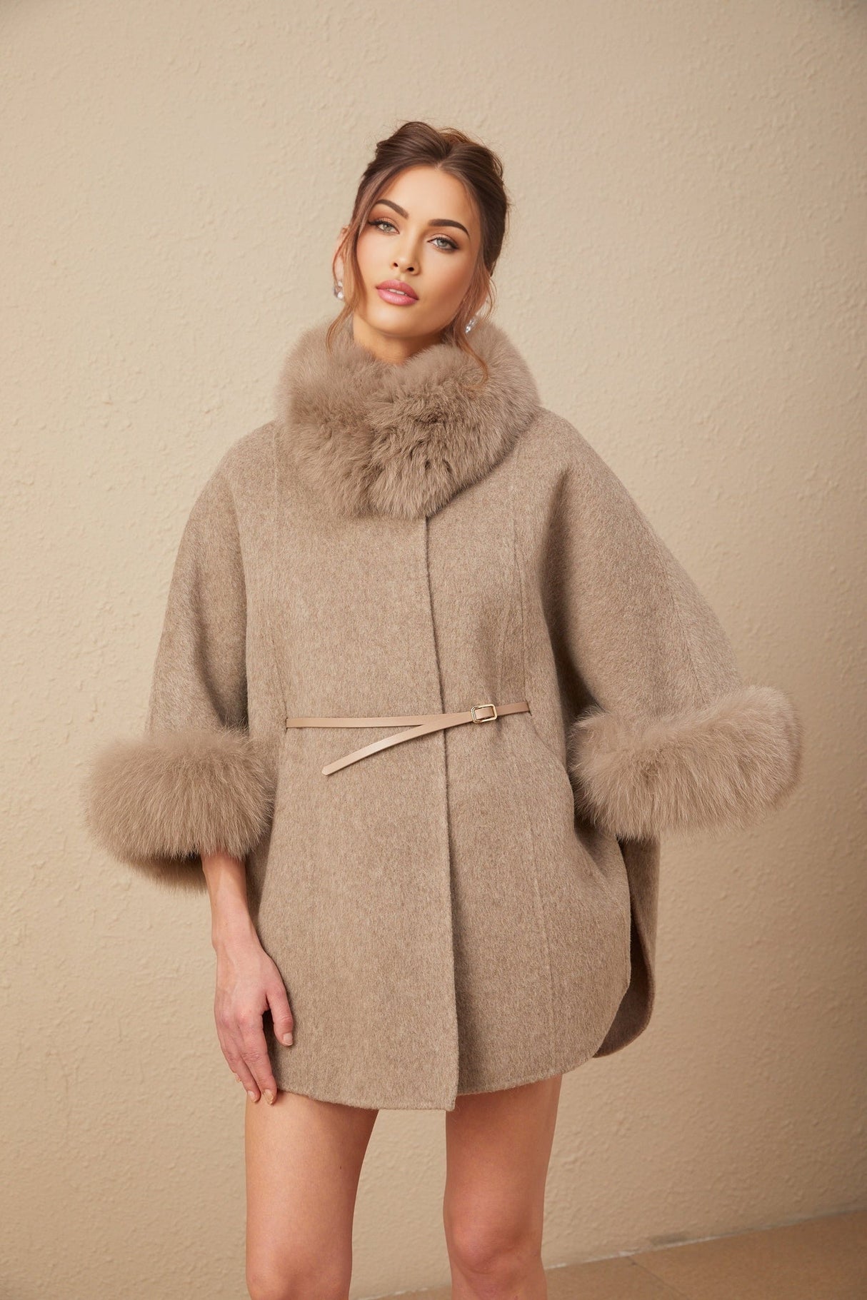 Woman wearing a brown wool cape coat with fur trim and belt cinched at the waist