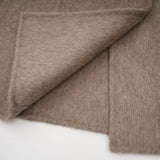 Woman wearing a brown wool cape coat with fur trim and belt