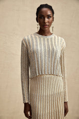 Woman wearing a champagne colored striped knit top and matching skirt set