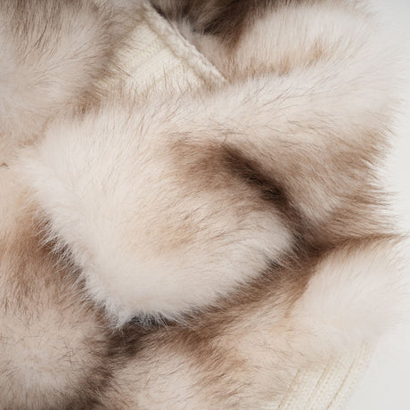 Woman wearing a cozy beige faux fur jacket with ribbed knit texture and long sleeves