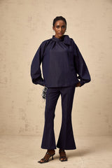 Woman wearing a denim blue matching set consisting of a flared blouse and trousers named Mathilde