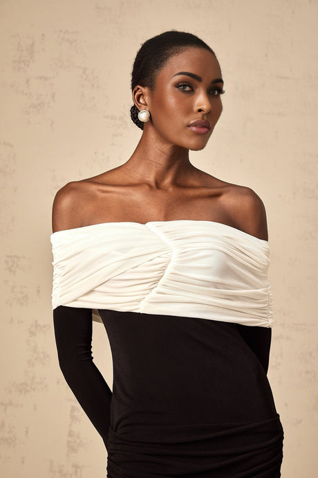 Woman wearing a fitted mini dress with color blocks and ruched detailing