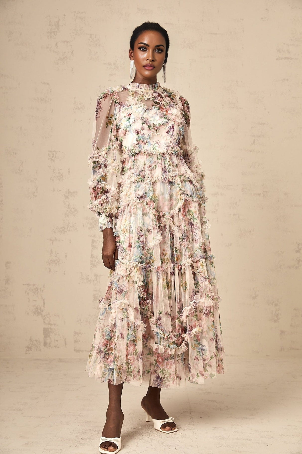 Woman wearing a floral patterned midi dress with ruffled details and tulle fabric