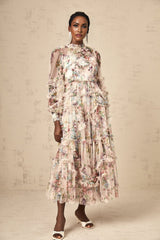 Woman wearing a floral patterned midi dress with ruffled details and tulle fabric