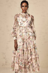 Woman wearing a floral patterned midi dress with ruffled tulle details and a fitted waist