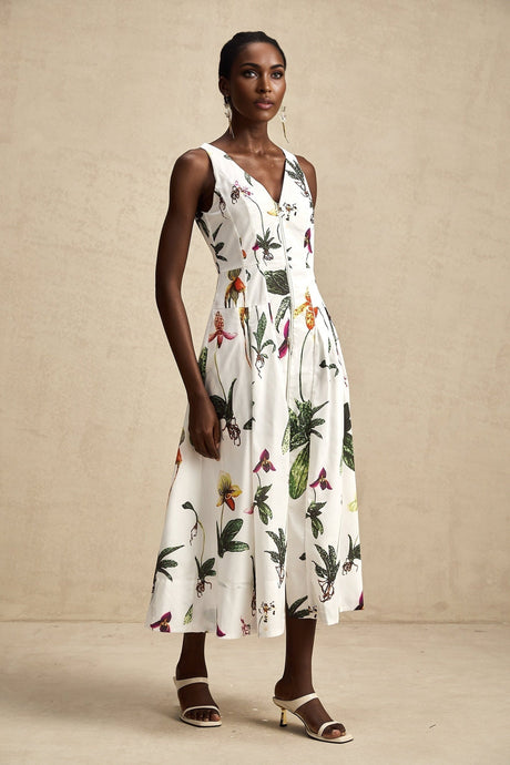 Woman wearing a floral print midi dress with vneck and poplin fabric in light colors with a flowing skirt